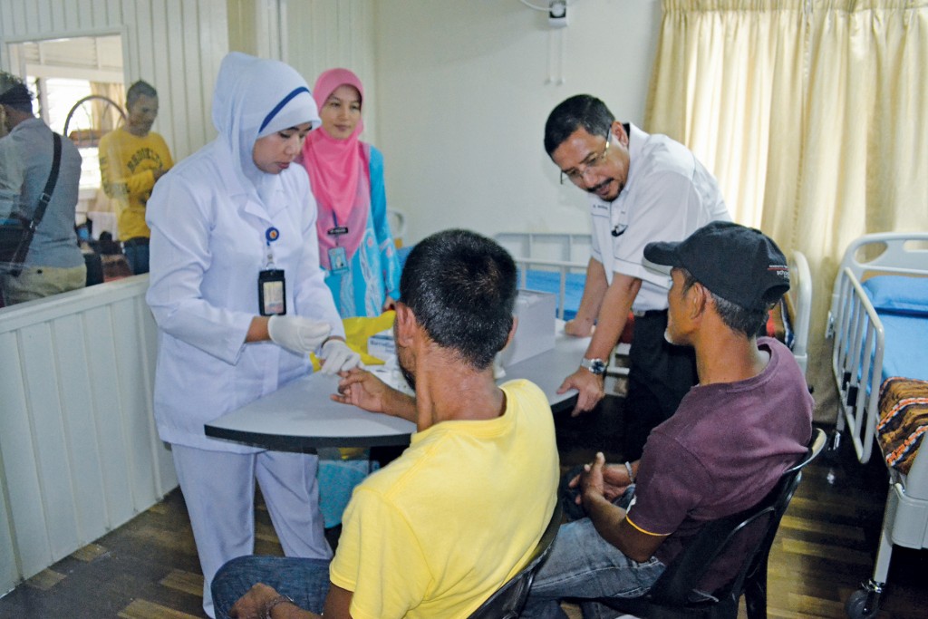 Syamsul (bukan nama sebenar), salah seorang penghuni Rumah SAHABAT (tengah, berbaju kuning) menjalani ujian darah yang dilakukan jururawat bertugas. 